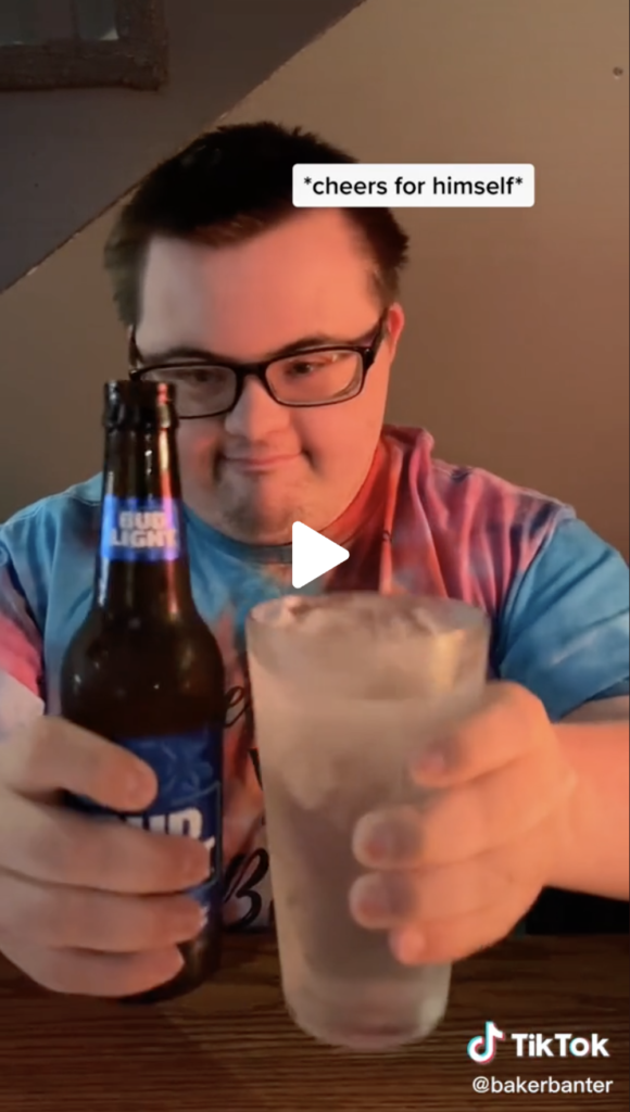 Creator bakerbanter in a tie dye shirt looking at a Bud Light beer and ice water in both hands