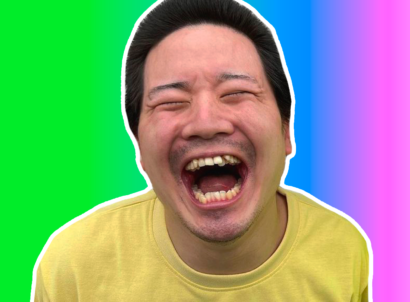 Japanese creator Junya smiling wide in a yellow t-shirt on a rainbow gradient background.