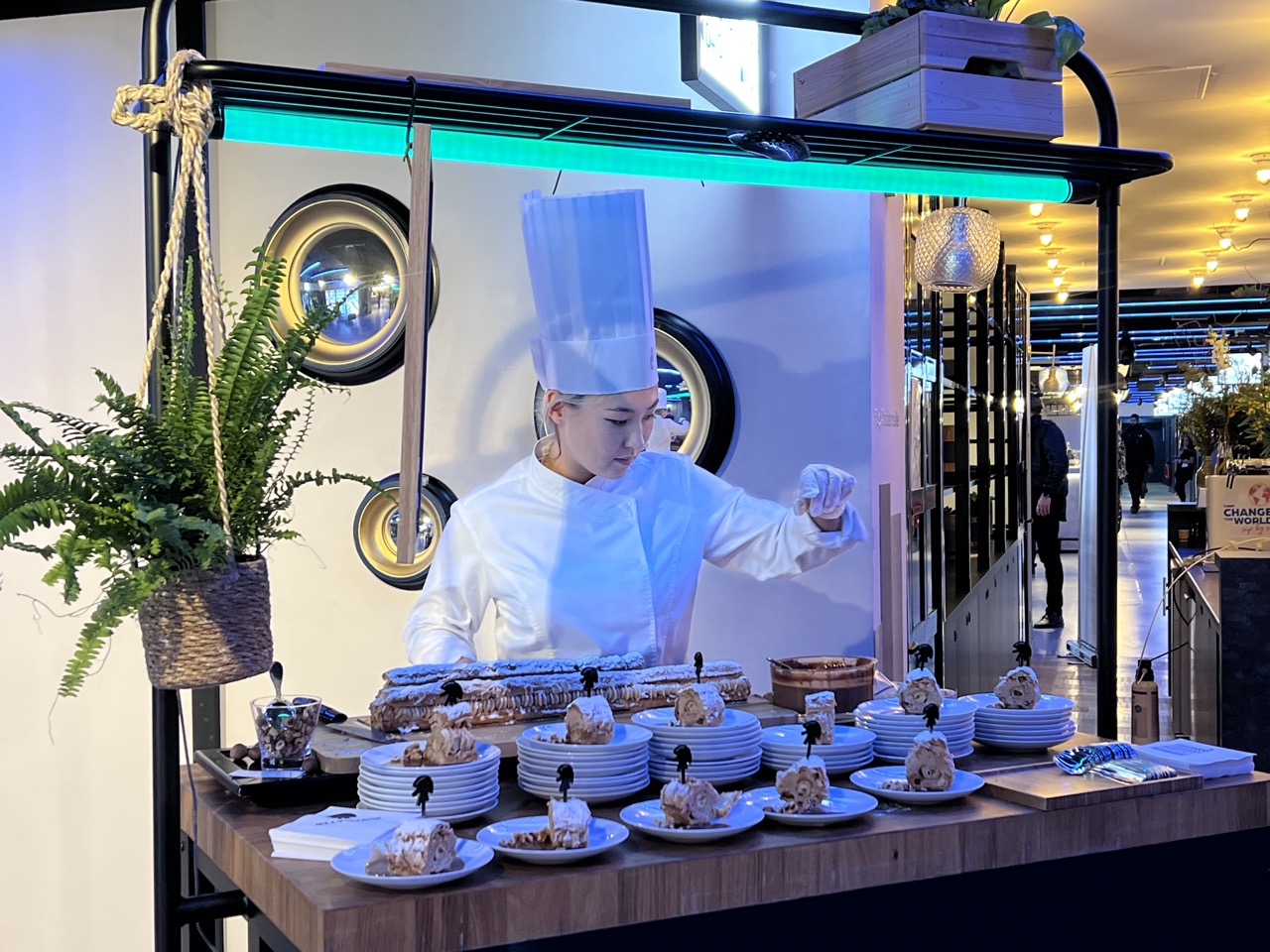 Female chef prepares gourmet desserts in an evening party setting