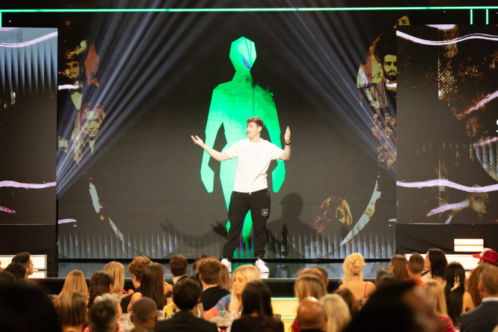 Creator Airrack holding his hands up on the air on stage looking out at the crowd at the 2022 Streamy Awards