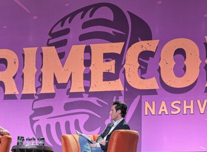 CrimeCon Nashville logo on purple backdrop behind a stage with two people sitting in chairs on a panel