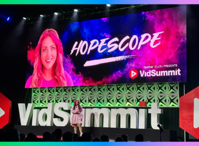 Creator HopeScope on stage in front of VidSummit sign speaking at a conference